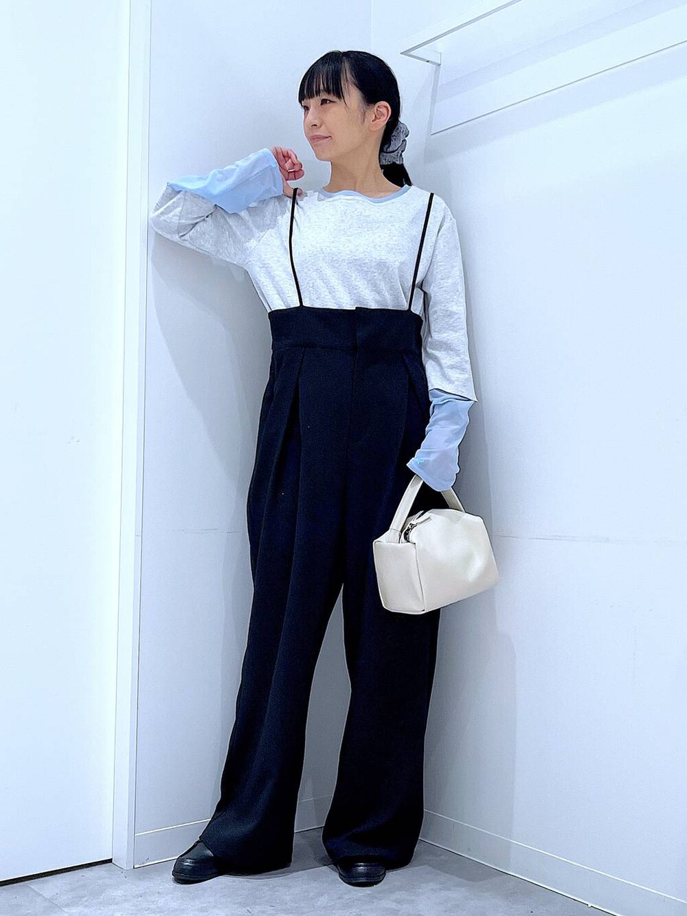 ホワイト系のショルダーバッグ、ブラック系のローファー、ブラック系のサロペット/オーバーオールを着用したレディースの春コーディネートの2枚目の写真