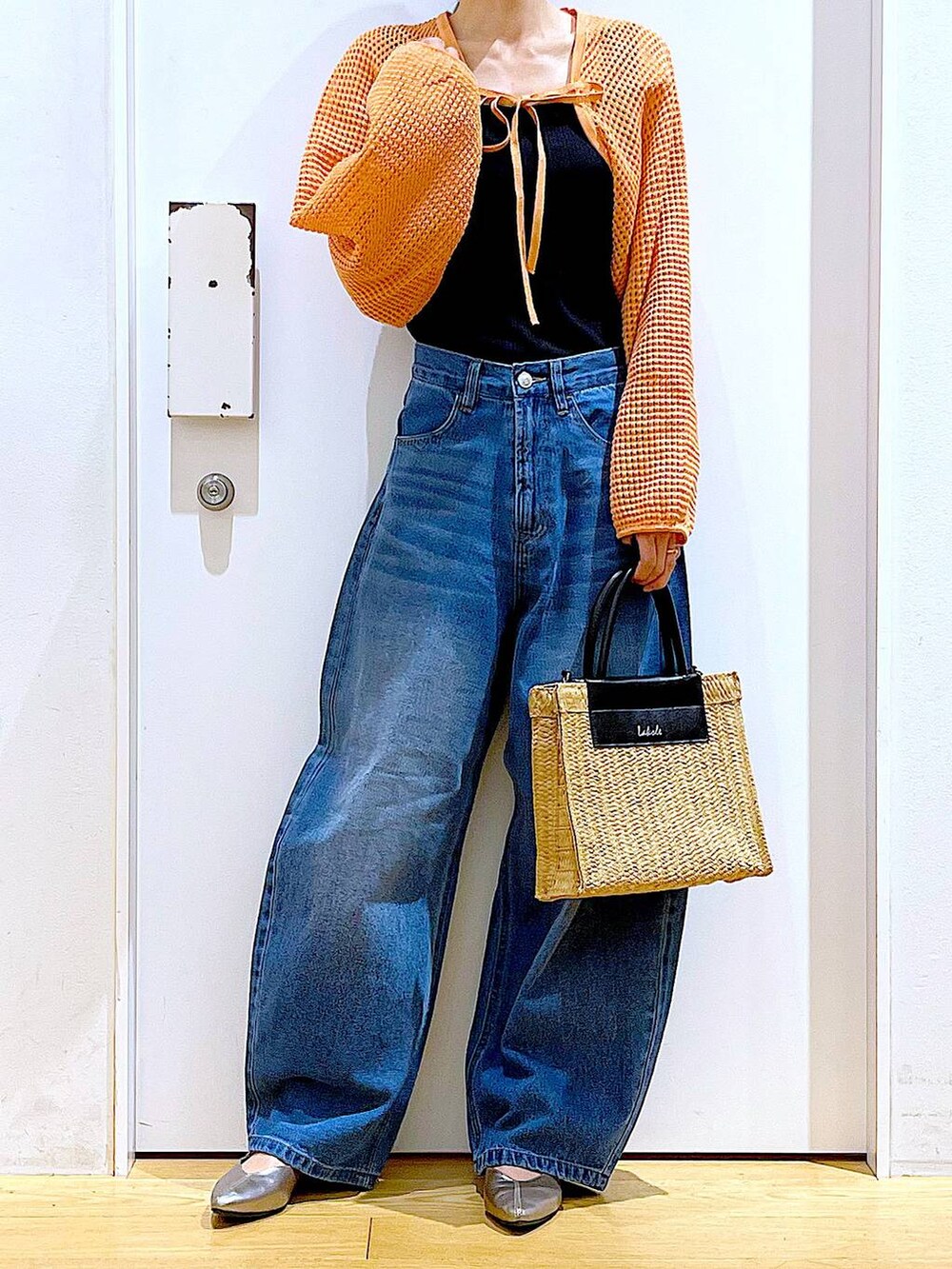 ブルー系のデニムパンツ、オレンジ系のカーディガン/ボレロ、その他のパンプスを着用したレディースの春コーディネートの6枚目の写真