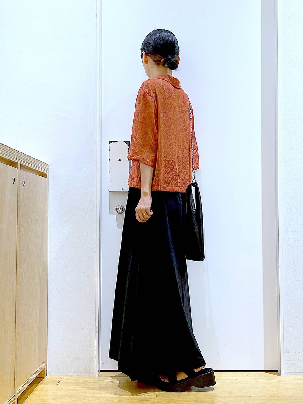 ブラック系のショルダーバッグ、レッド系のシャツ/ブラウス、ブラック系のスカートを着用したレディースの夏コーディネートの3枚目の写真