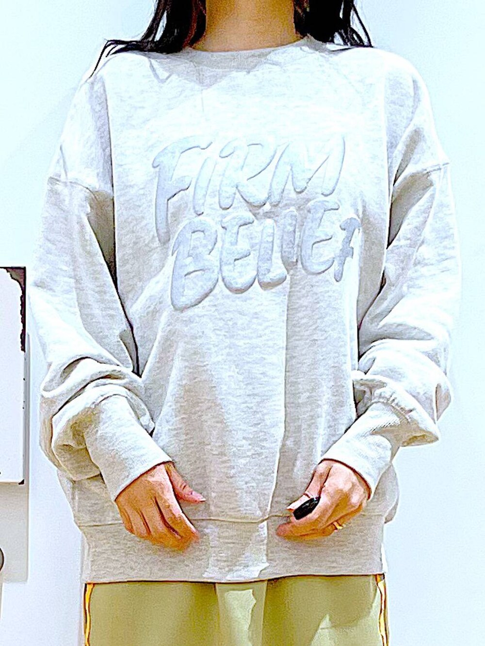 ベージュ系のスウェット、ベージュ系のブーツ、ホワイト系のトートバッグを着用したレディースの冬コーディネートの7枚目の写真