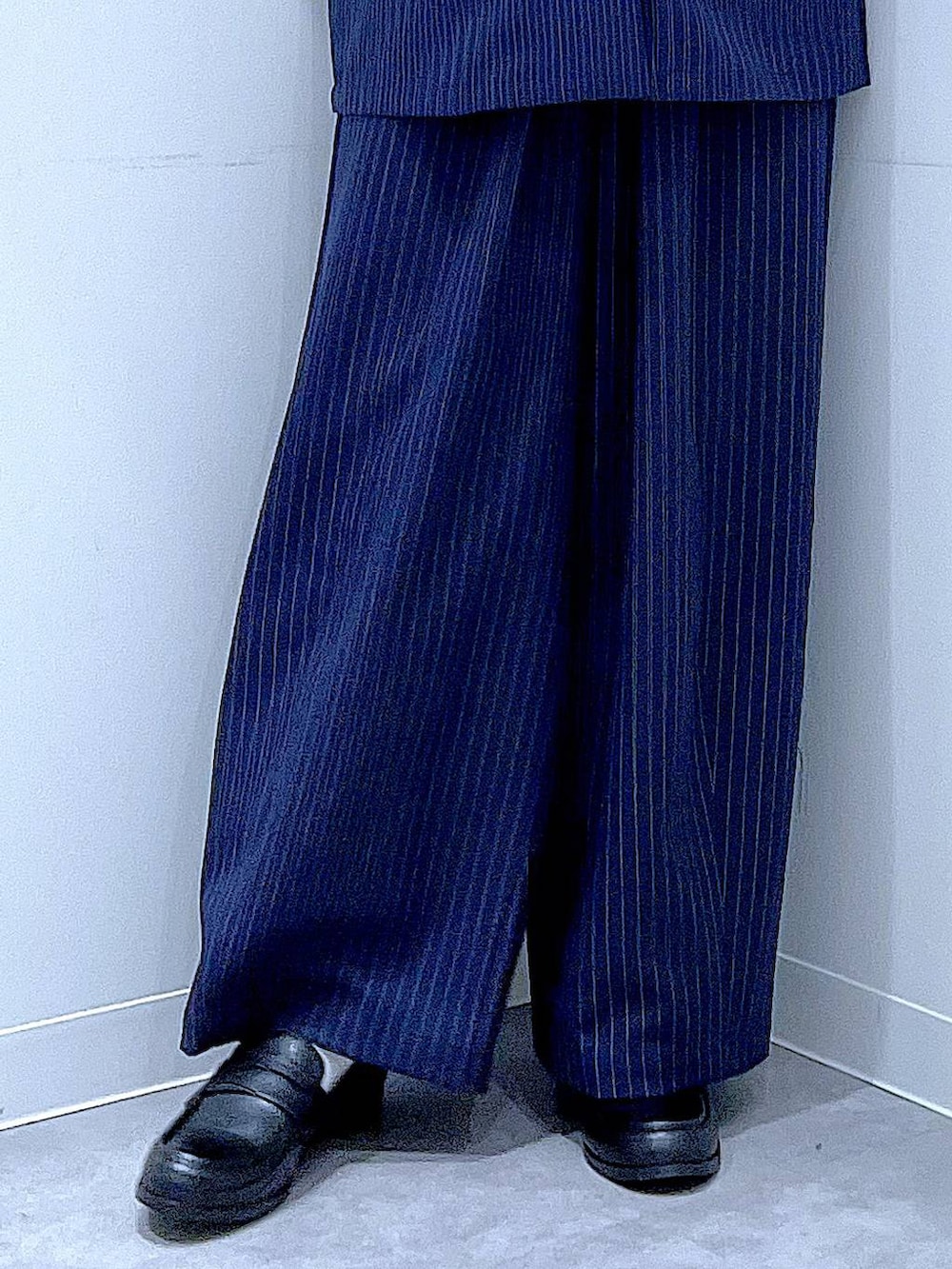 ホワイト系のショルダーバッグ、ブルー系のスラックス、ブルー系のベストを着用したレディースの冬コーディネートの8枚目の写真