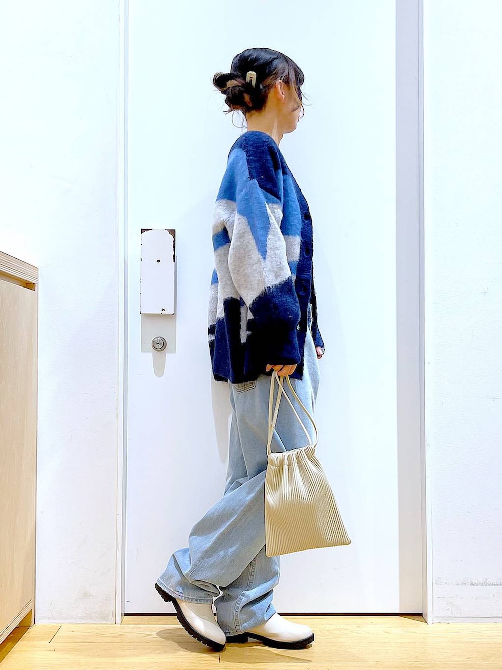 ベージュ系のショルダーバッグ、ベージュ系のブーツ、ブラック系のニット/セーターを着用したレディースの冬コーディネートの4枚目の写真