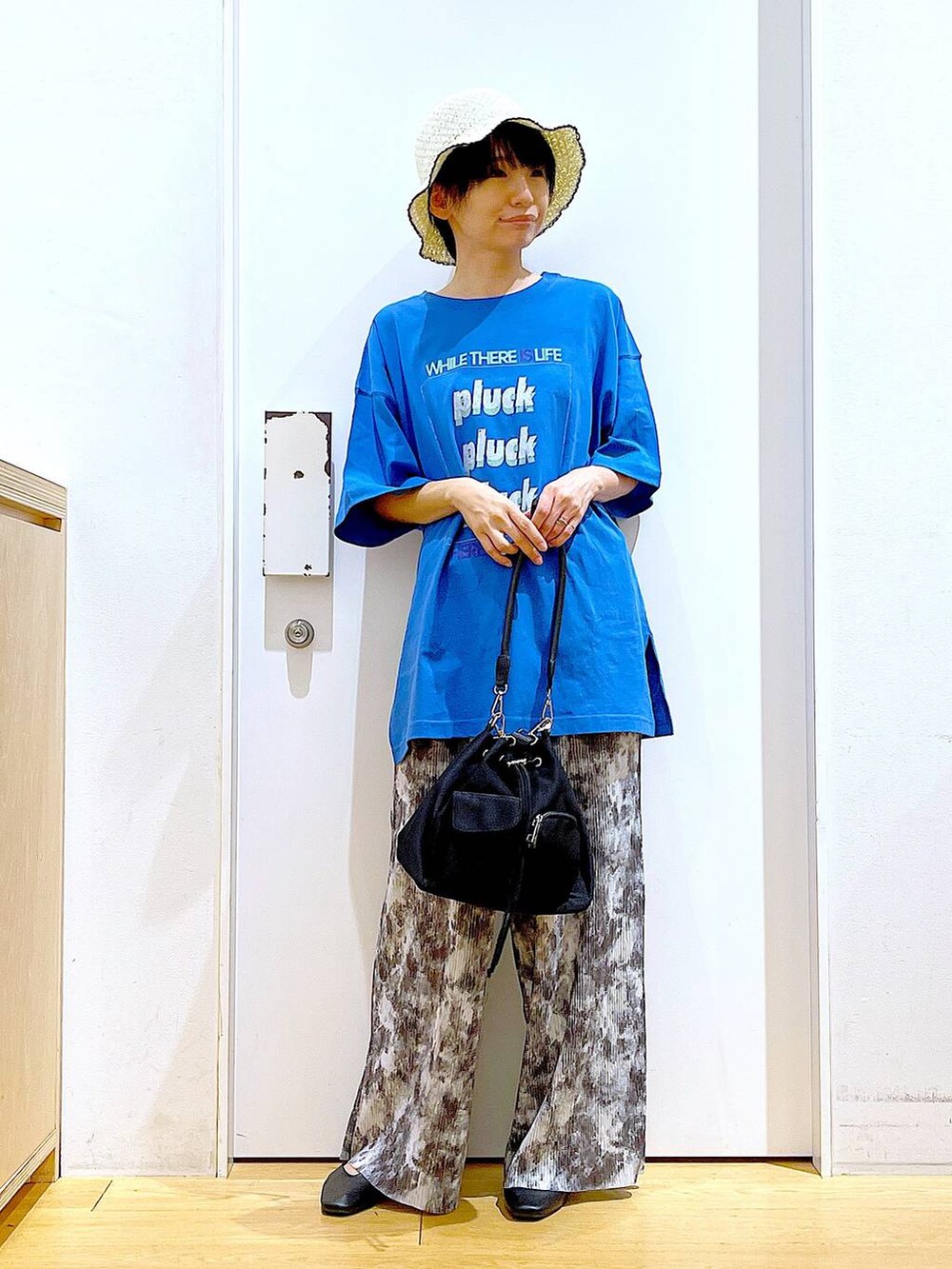 ブラック系のパンプス、グレー系のその他パンツ、ブルー系のTシャツ/カットソーを着用したレディースの春コーディネートの2枚目の写真