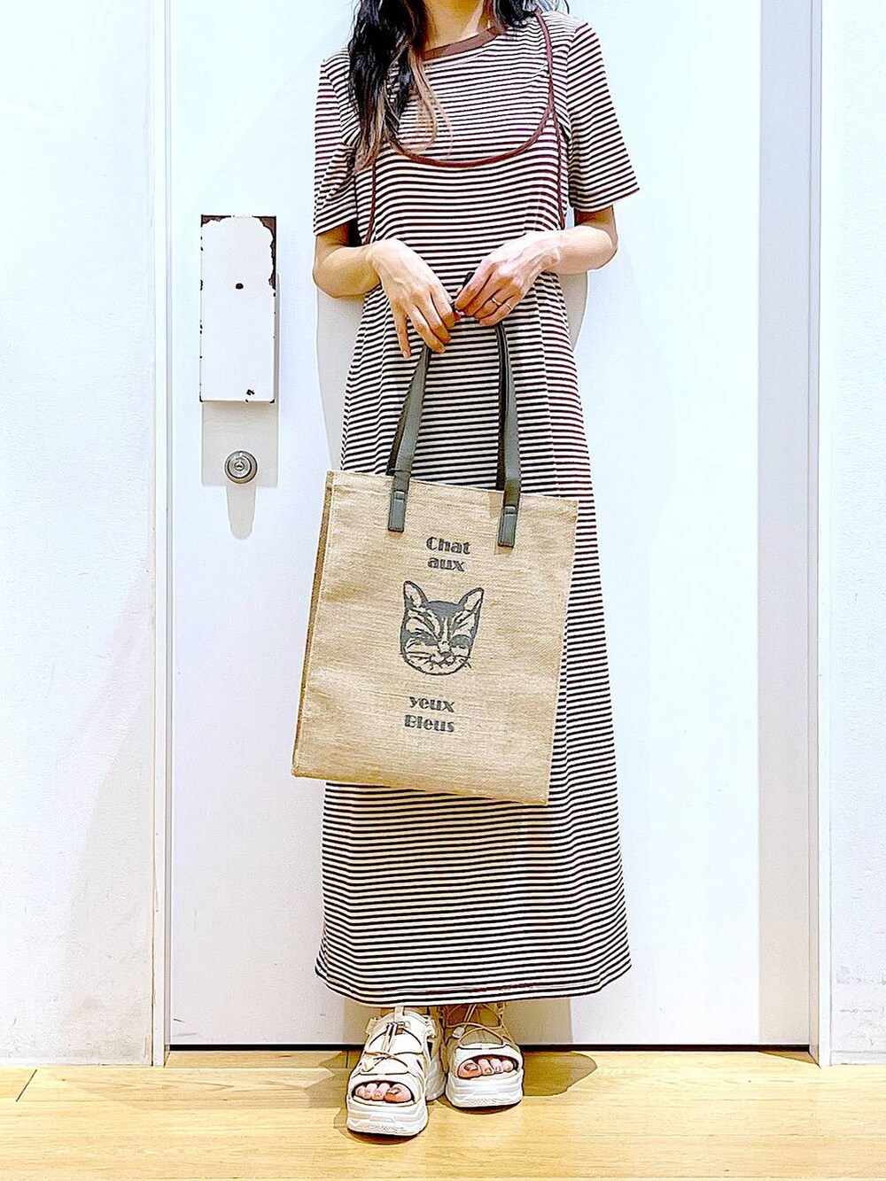 ベージュ系のサンダル、グレー系のトートバッグ、ベージュ系のワンピースを着用したレディースの夏コーディネートの6枚目の写真