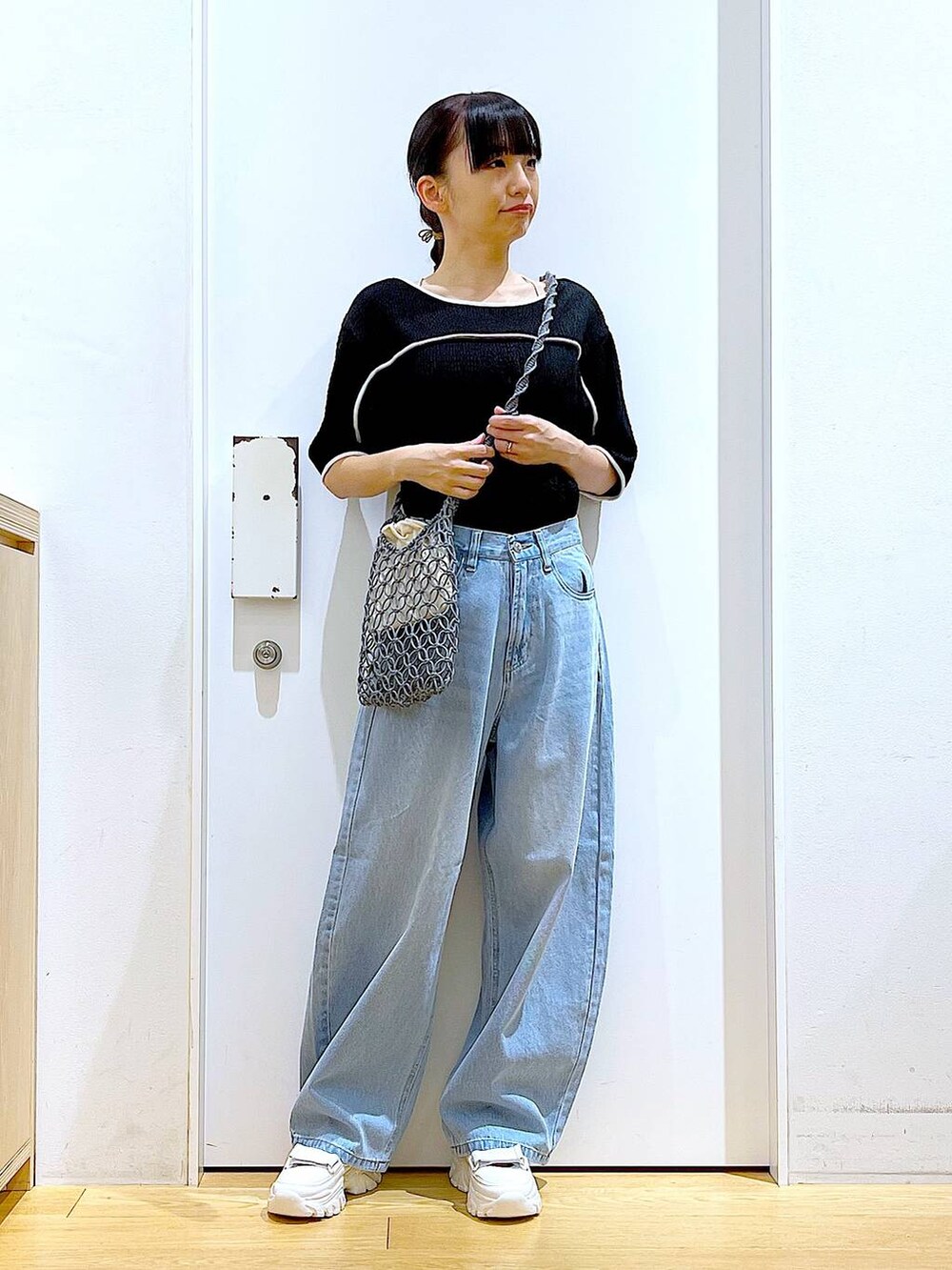 ホワイト系のスニーカー、ブルー系のデニムパンツ、グレー系のショルダーバッグを着用したレディースの夏コーディネートの2枚目の写真