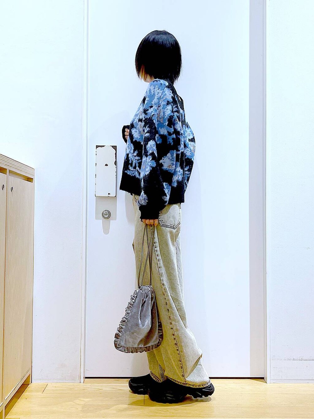 ブラック系のブーツ、グレー系のショルダーバッグ、ベージュ系のデニムパンツを着用したレディースの秋コーディネートの3枚目の写真