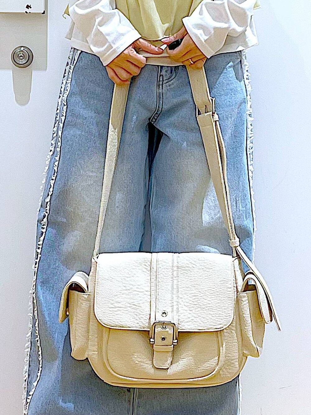 ホワイト系のスニーカー、ブルー系のデニムパンツ、ベージュ系のその他トップスを着用したレディースの春コーディネートの9枚目の写真