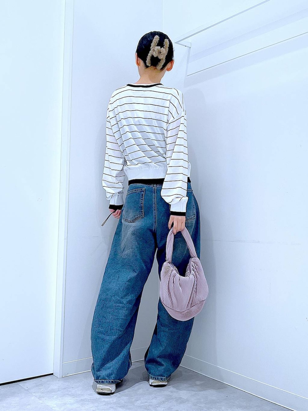 ブルー系のデニムパンツ、ピンク系のショルダーバッグ、ホワイト系のカーディガン/ボレロを着用したレディースの春コーディネートの5枚目の写真