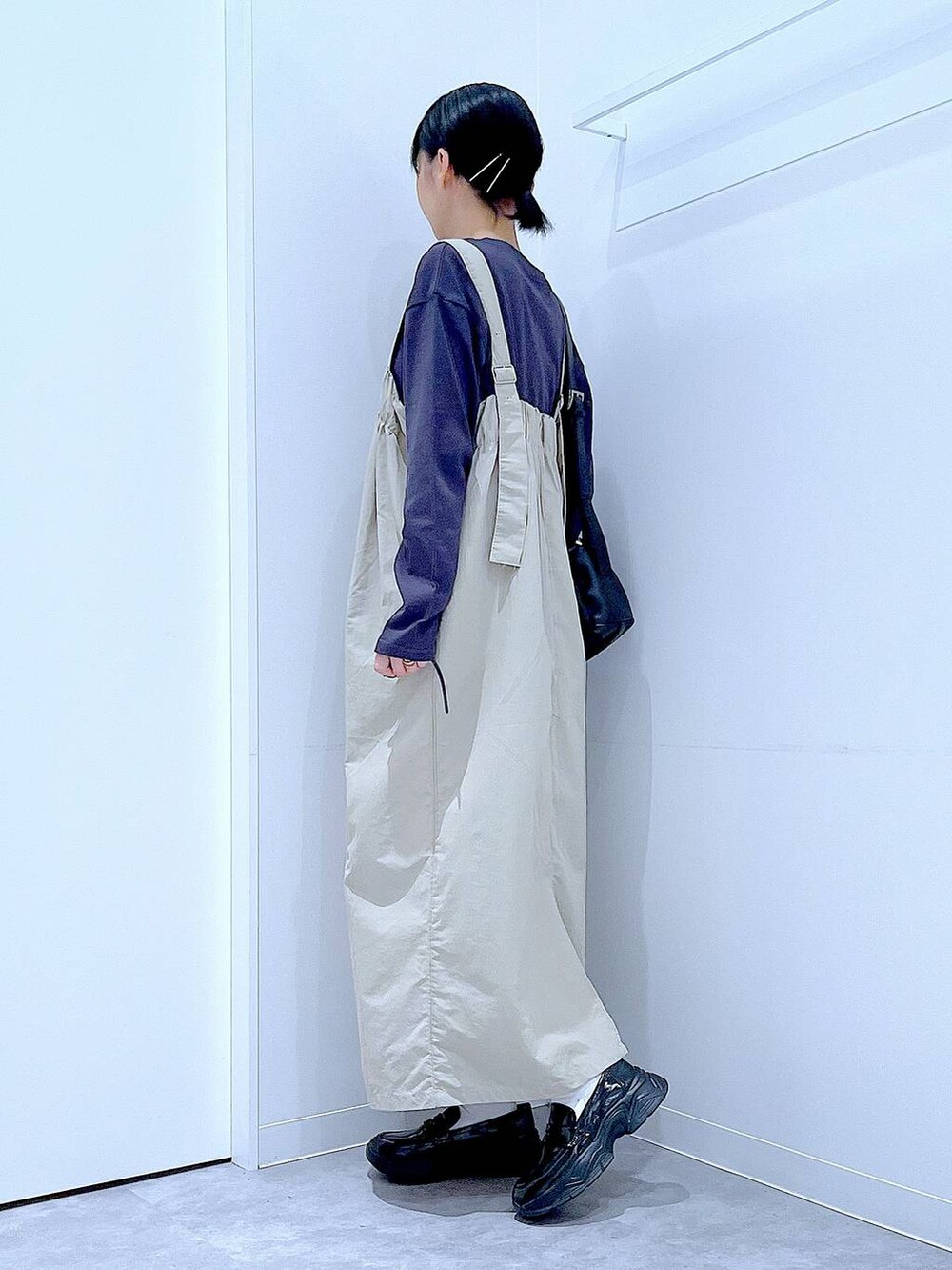 ブラック系のショルダーバッグ、ブラック系のローファー、グレー系のワンピースを着用したレディースの秋コーディネートの3枚目の写真