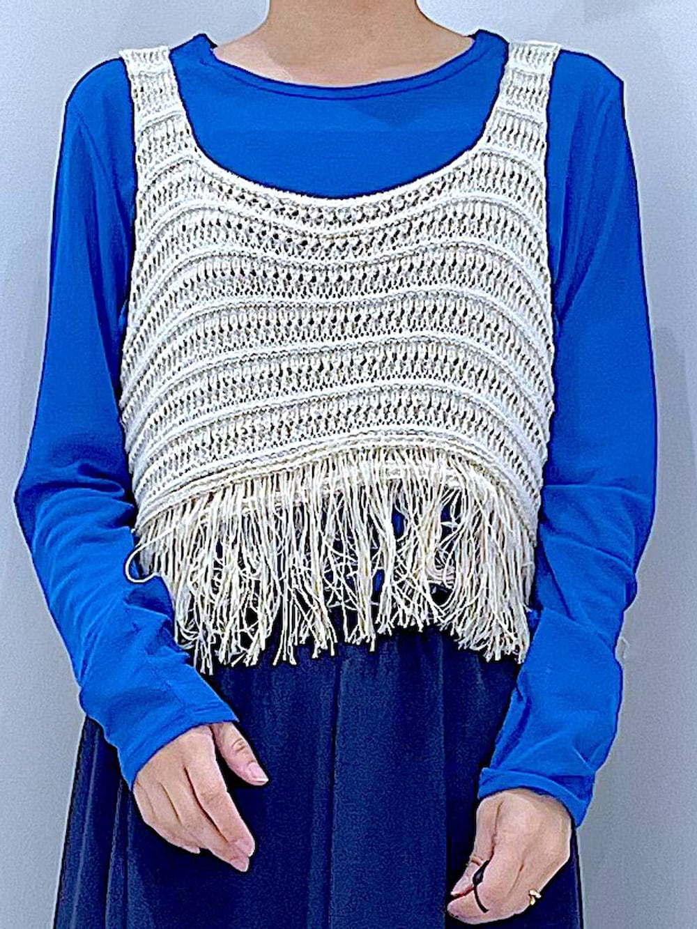 ブルー系のTシャツ/カットソー、ブラック系のショルダーバッグ、ベージュ系のベストを着用したレディースの春コーディネートの7枚目の写真