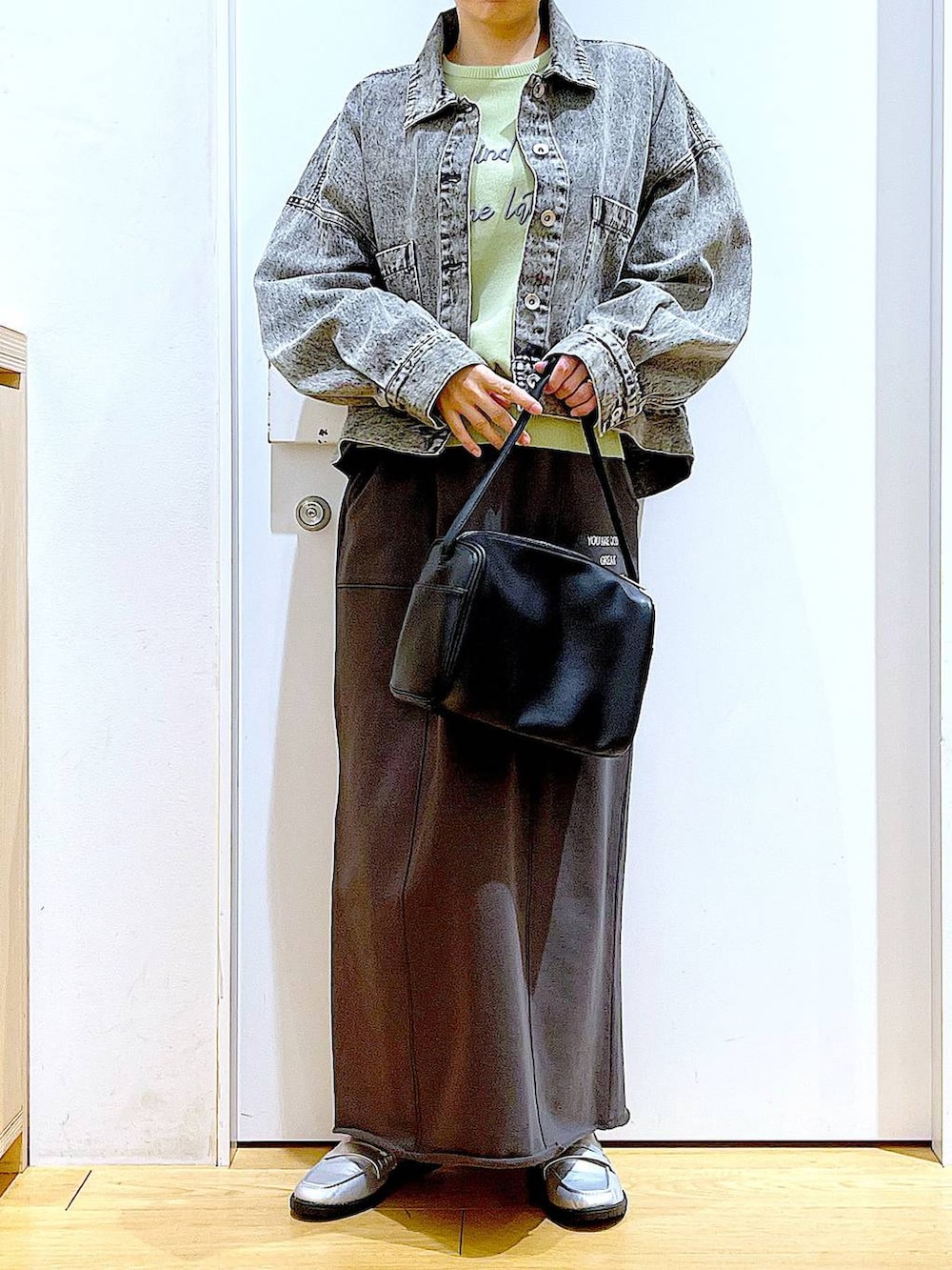 ブラック系のショルダーバッグ、シルバー系のローファー、ブラック系のデニムジャケットを着用したレディースの春コーディネートの6枚目の写真