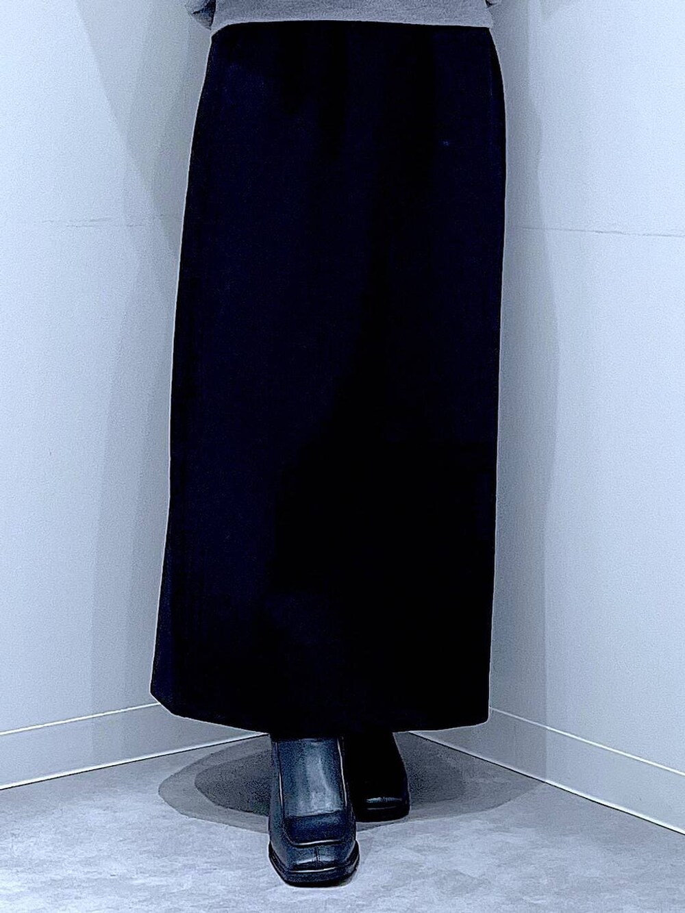 ブラック系のスカート、ブラック系のブーツ、ブラウン系のショルダーバッグを着用したレディースの冬コーディネートの8枚目の写真