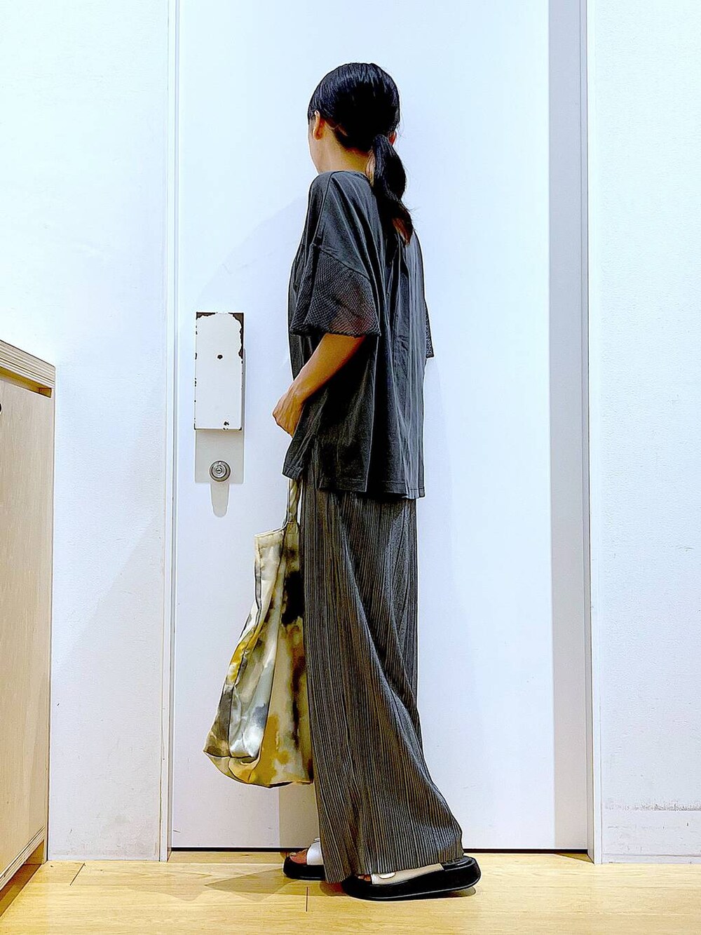 ホワイト系のサンダル、イエロー系のトートバッグ、グレー系のその他パンツを着用したレディースの秋コーディネートの3枚目の写真