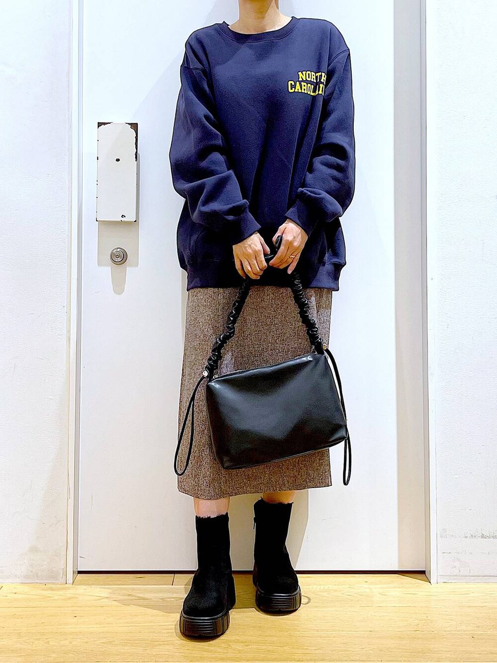 ブラック系のショルダーバッグ、ブラック系のブーツ、ブラウン系のワンピースを着用したレディースの冬コーディネートの6枚目の写真