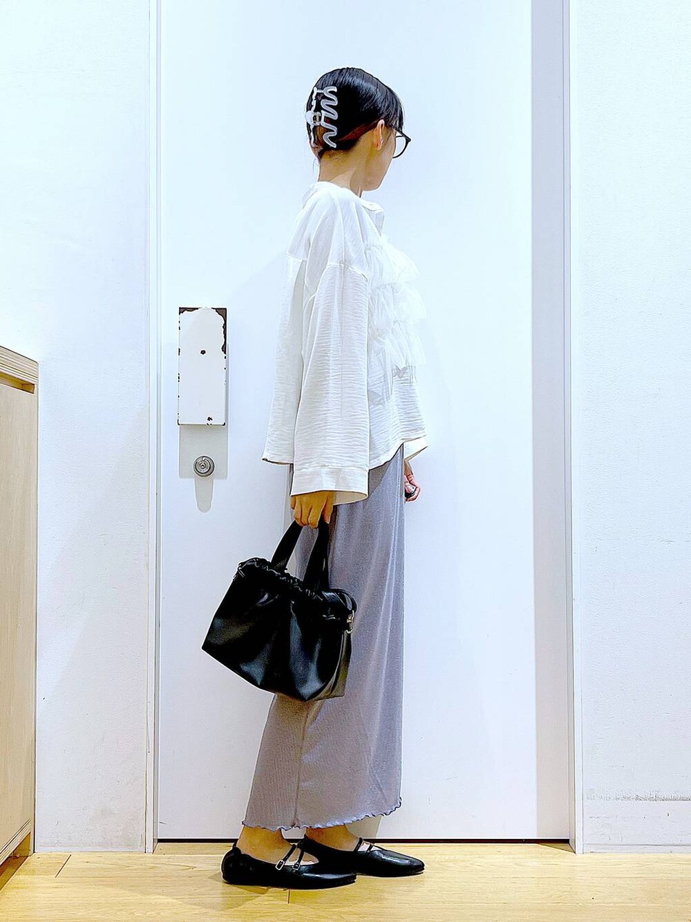 パープル系のスカート、ブラック系のショルダーバッグ、ブラック系のパンプスを着用したレディースの秋コーディネートの4枚目の写真