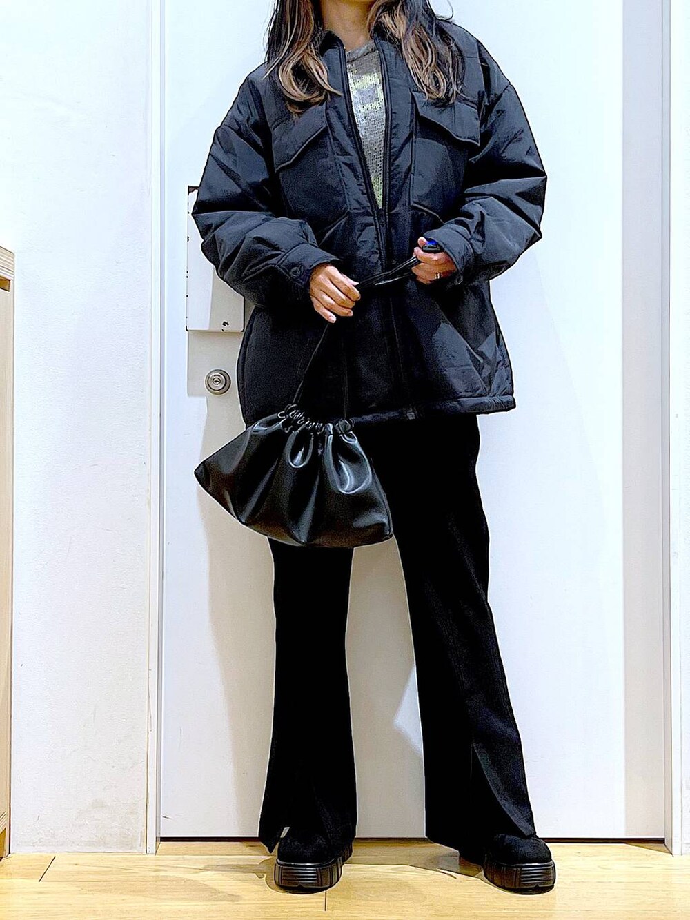 ブラック系のブルゾン、ブラック系のショルダーバッグ、ブラック系のブーツを着用したレディースの冬コーディネートの6枚目の写真