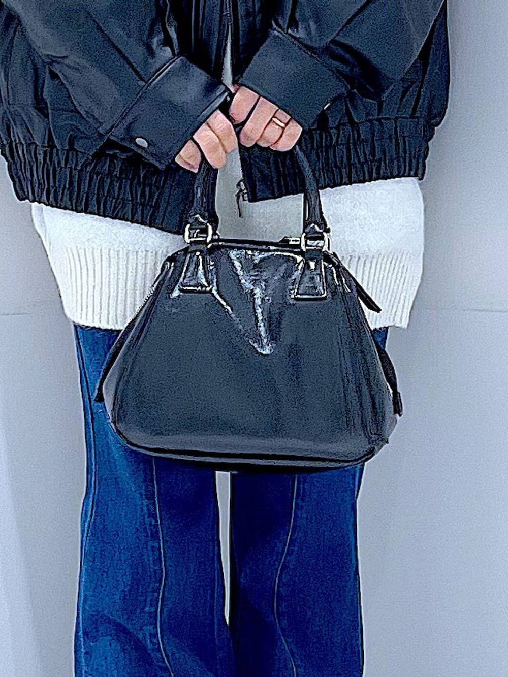 ブラック系のブルゾン、ブラック系のブーツ、ブラック系のショルダーバッグを着用したレディースの冬コーディネートの9枚目の写真