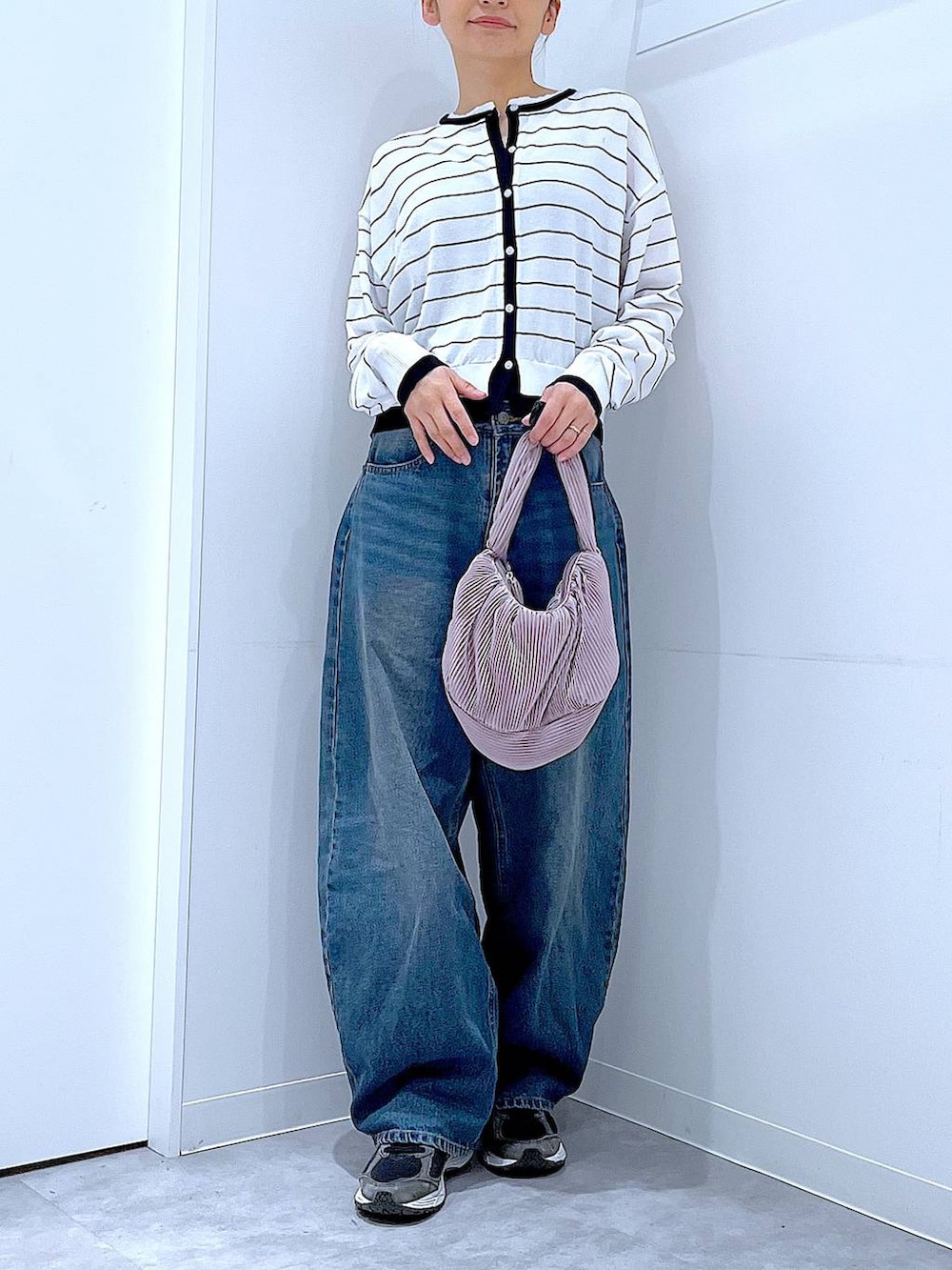 ブルー系のデニムパンツ、ピンク系のショルダーバッグ、ホワイト系のカーディガン/ボレロを着用したレディースの春コーディネートの6枚目の写真