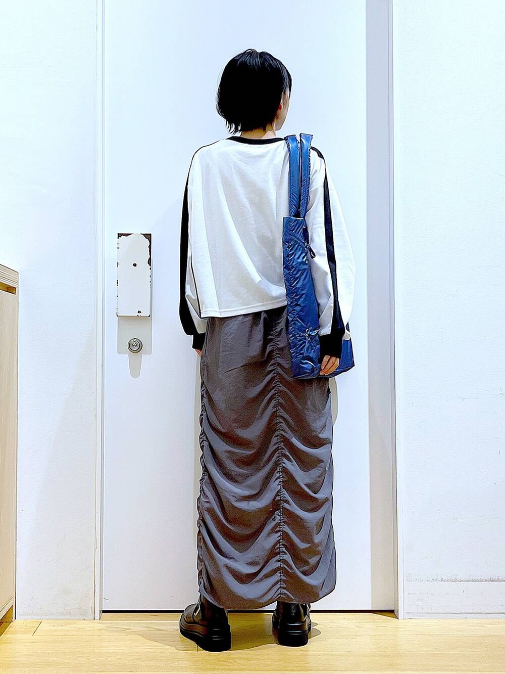 ブラック系のブーツ、ブルー系のトートバッグ、ホワイト系のTシャツ/カットソーを着用したレディースの秋コーディネートの5枚目の写真