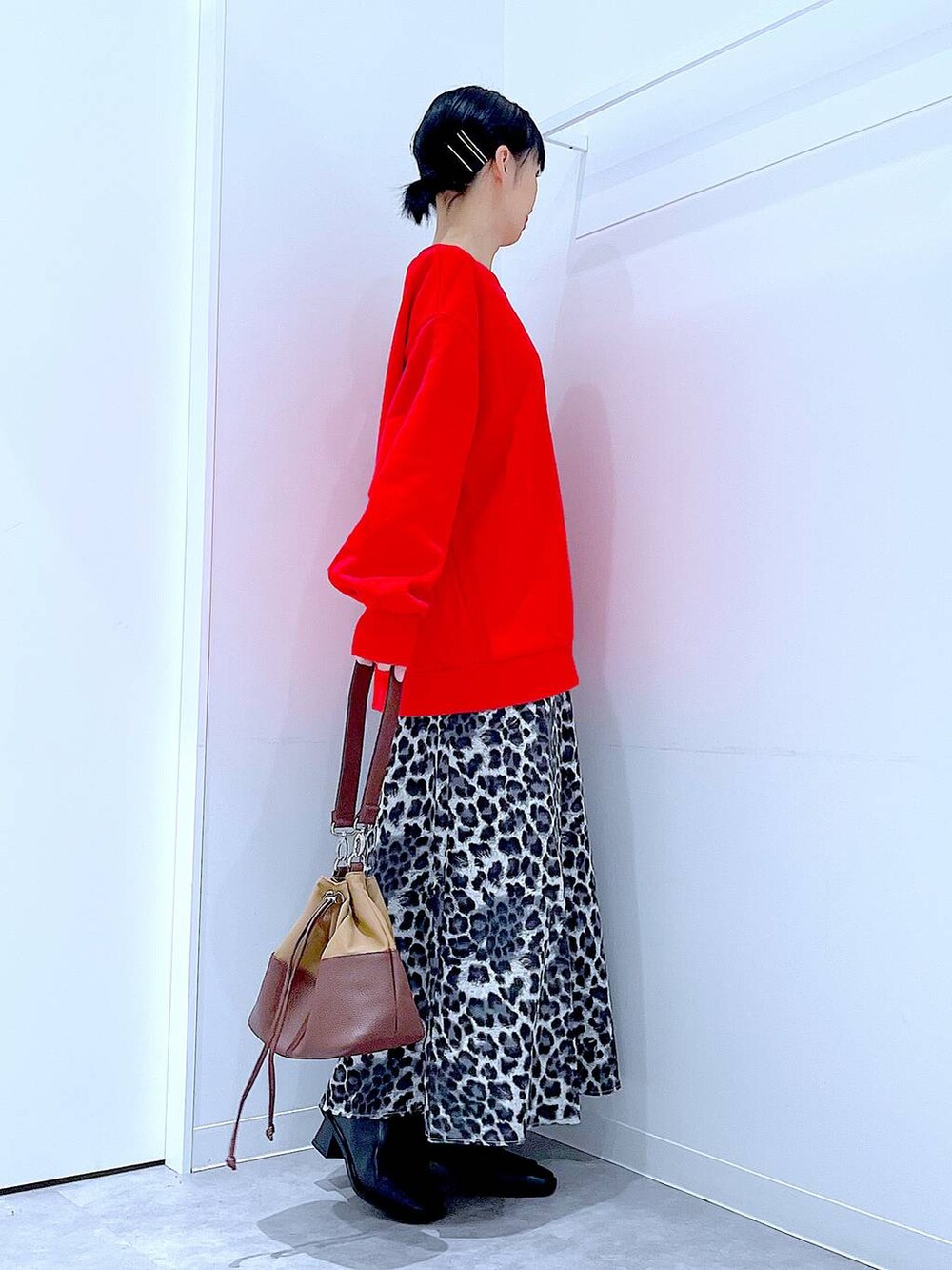 ベージュ系のショルダーバッグ、ブラック系のブーツ、グレー系のスカートを着用したレディースの秋コーディネートの4枚目の写真