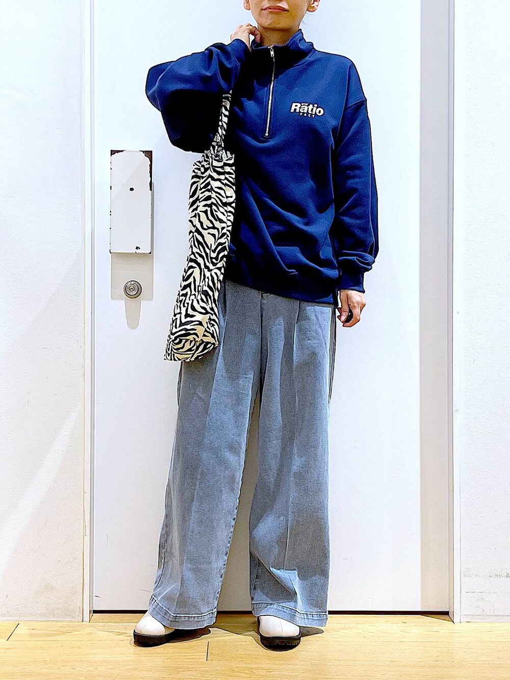 ブルー系のデニムパンツ、ブルー系のスウェット、ベージュ系のブーツを着用したレディースの春コーディネートの6枚目の写真