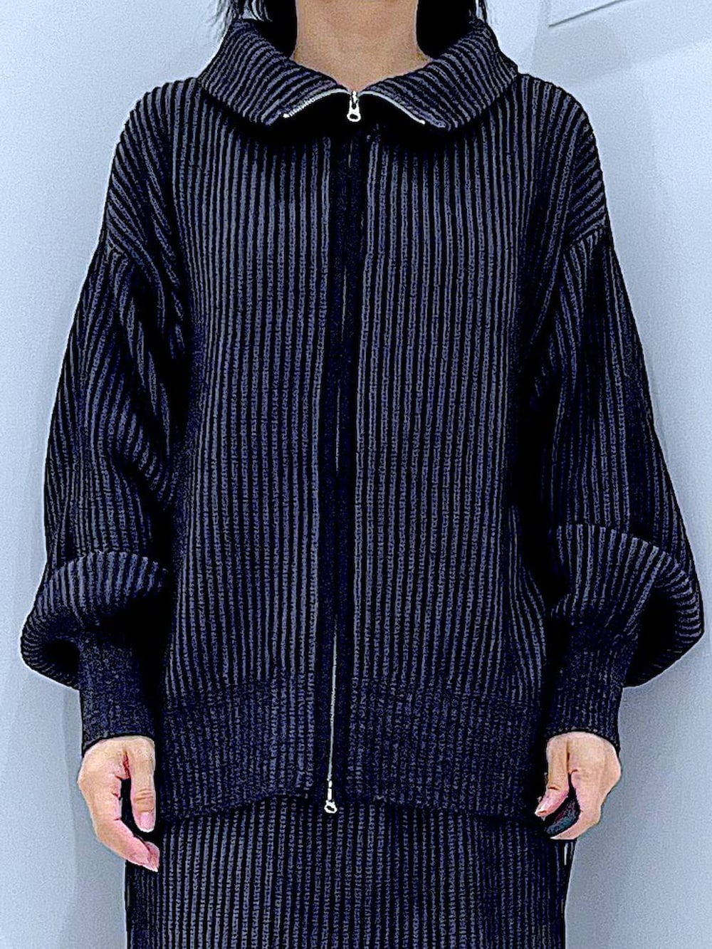 ホワイト系のハンドバッグ、ブラック系のスカート、ブラック系のニット/セーターを着用したレディースの秋コーディネートの7枚目の写真