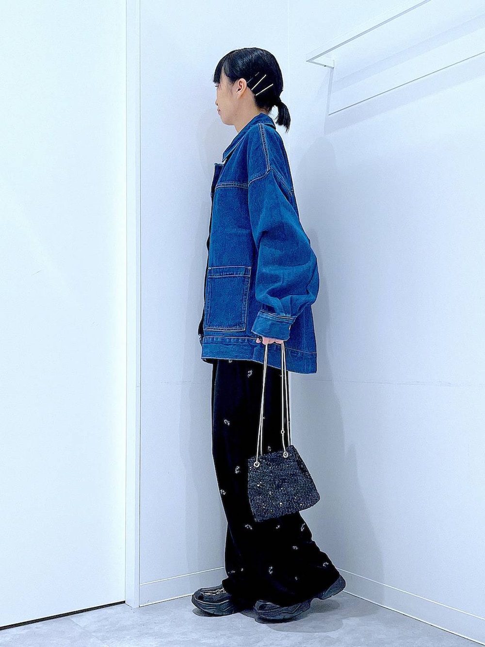 ブラック系のショルダーバッグ、ブラック系のローファー、ブルー系のデニムジャケットを着用したレディースの秋コーディネートの3枚目の写真