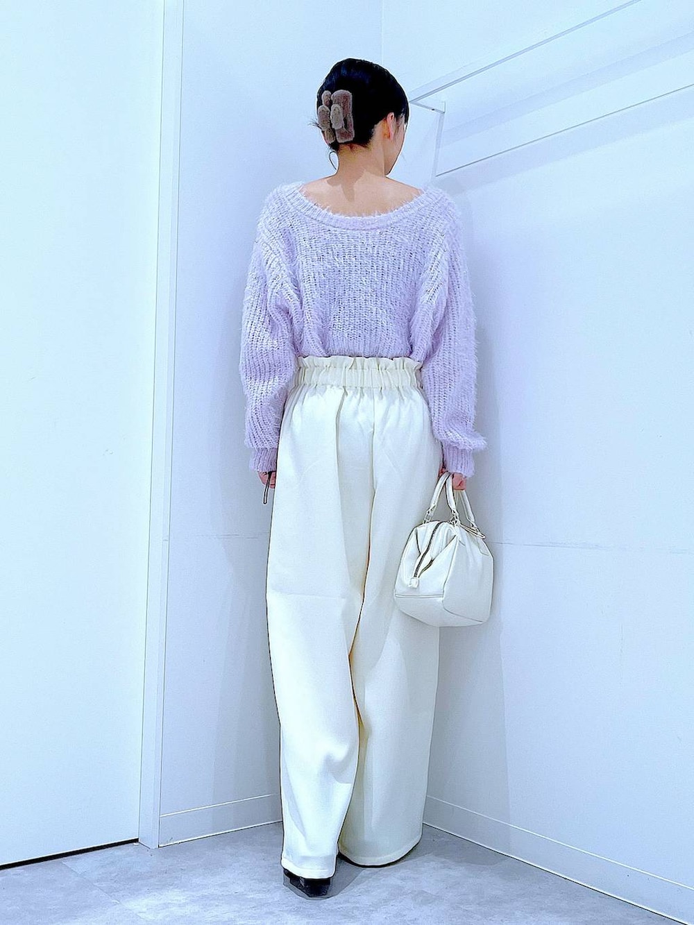 ブラック系のブーツ、ホワイト系のショルダーバッグ、パープル系のニット/セーターを着用したレディースの冬コーディネートの5枚目の写真