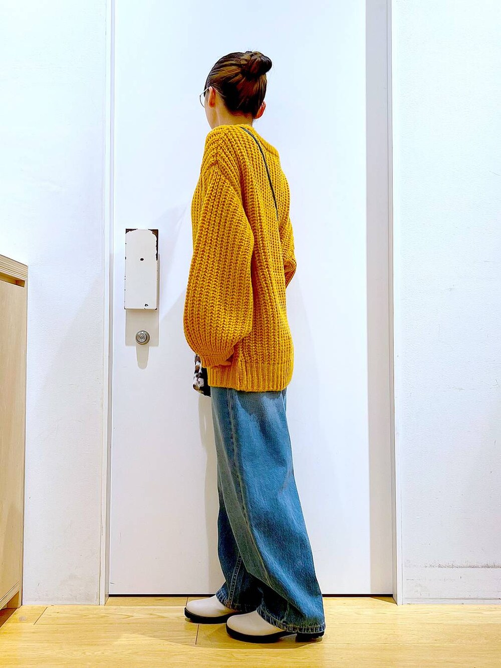 ベージュ系のブーツ、その他のショルダーバッグ、ブルー系のデニムパンツを着用したレディースの冬コーディネートの4枚目の写真