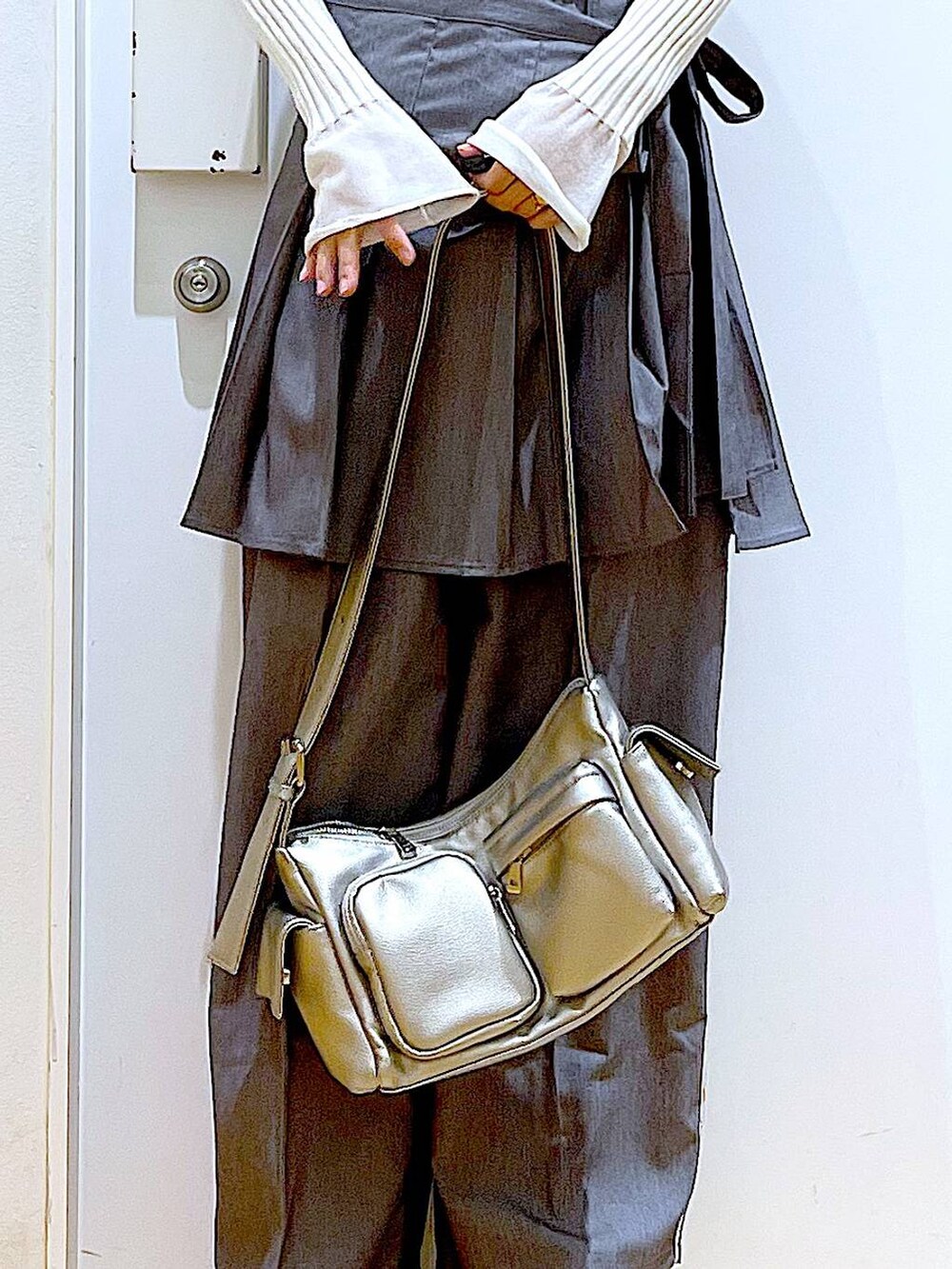 ホワイト系のニット/セーター、グレー系のスラックス、グレー系のスカートを着用したレディースの秋コーディネートの9枚目の写真