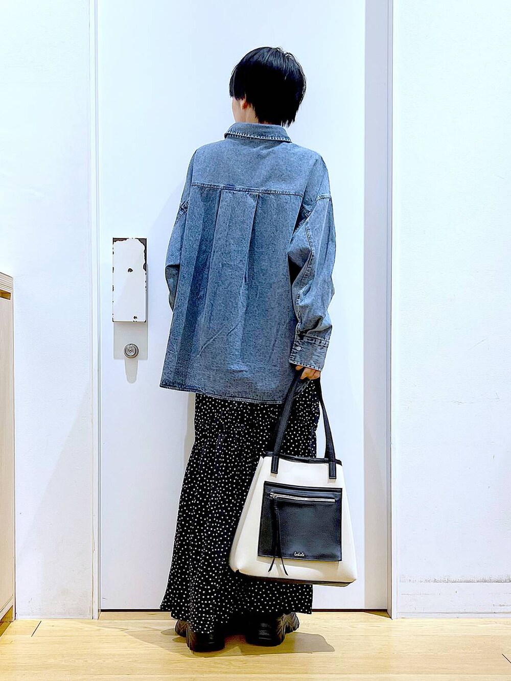 ブラック系のブーツ、ブルー系のシャツ/ブラウス、ホワイト系のトートバッグを着用したレディースの春コーディネートの5枚目の写真