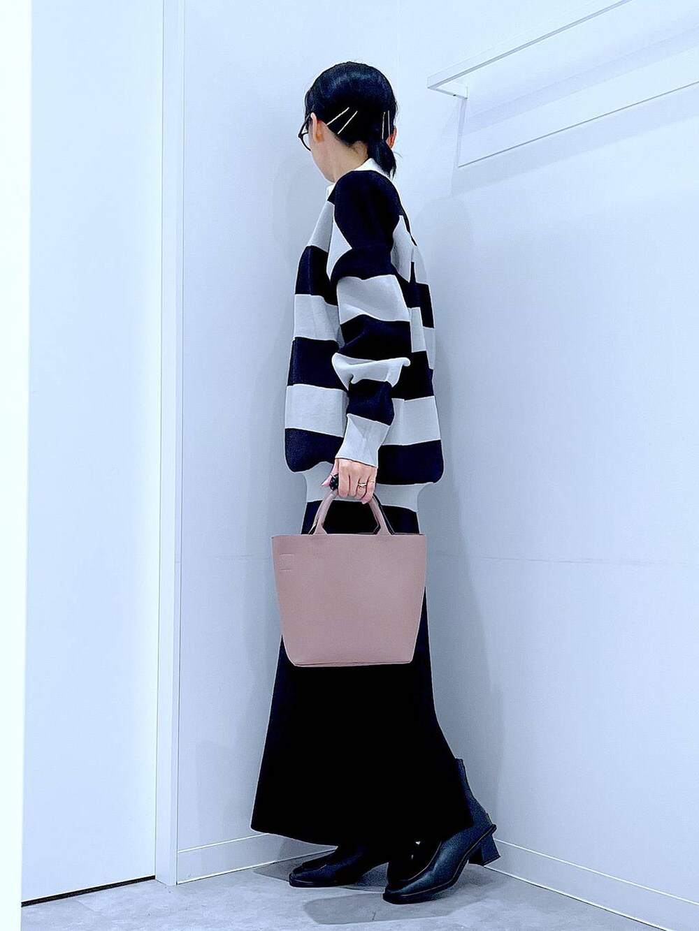 ブラック系のショルダーバッグ、ブラック系のニット/セーター、ブラック系のブーツを着用したレディースの秋コーディネートの3枚目の写真