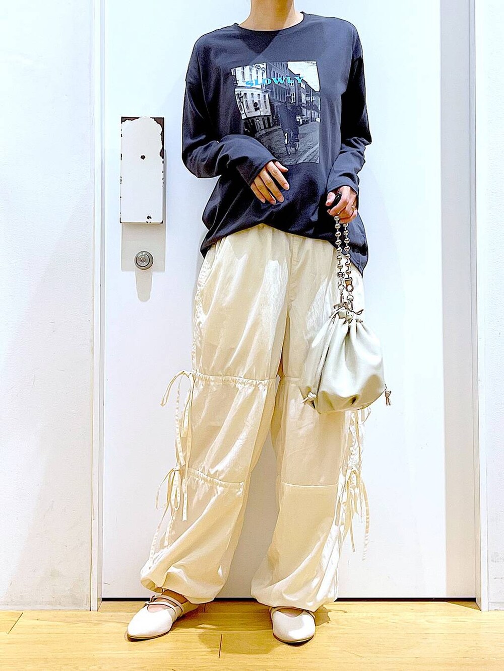 ベージュ系のショルダーバッグ、ホワイト系のパンプス、ホワイト系のその他パンツを着用したレディースの秋コーディネートの6枚目の写真