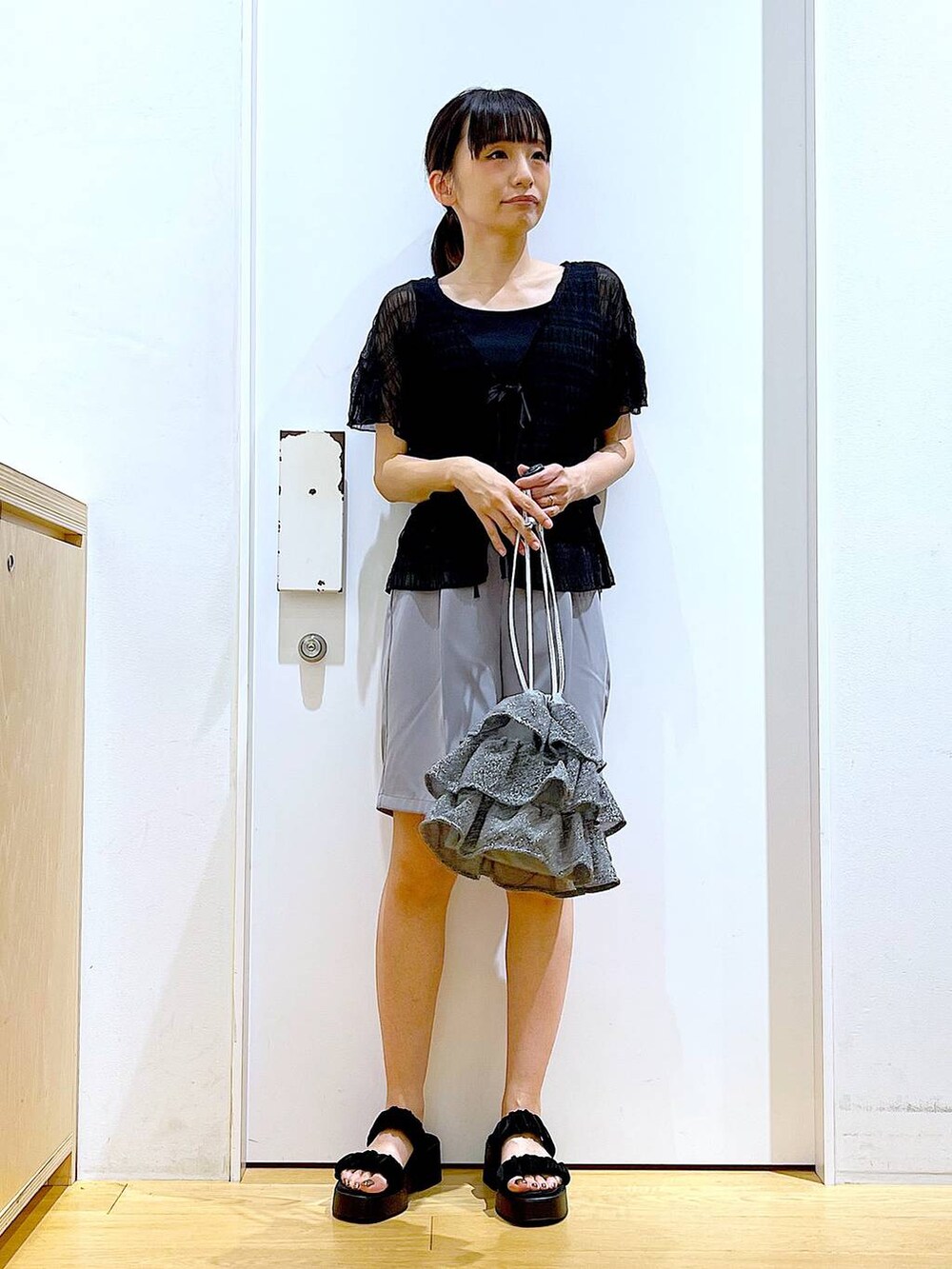 シルバー系のショルダーバッグ、グレー系のその他パンツ、ブラック系のサンダルを着用したレディースの夏コーディネートの2枚目の写真