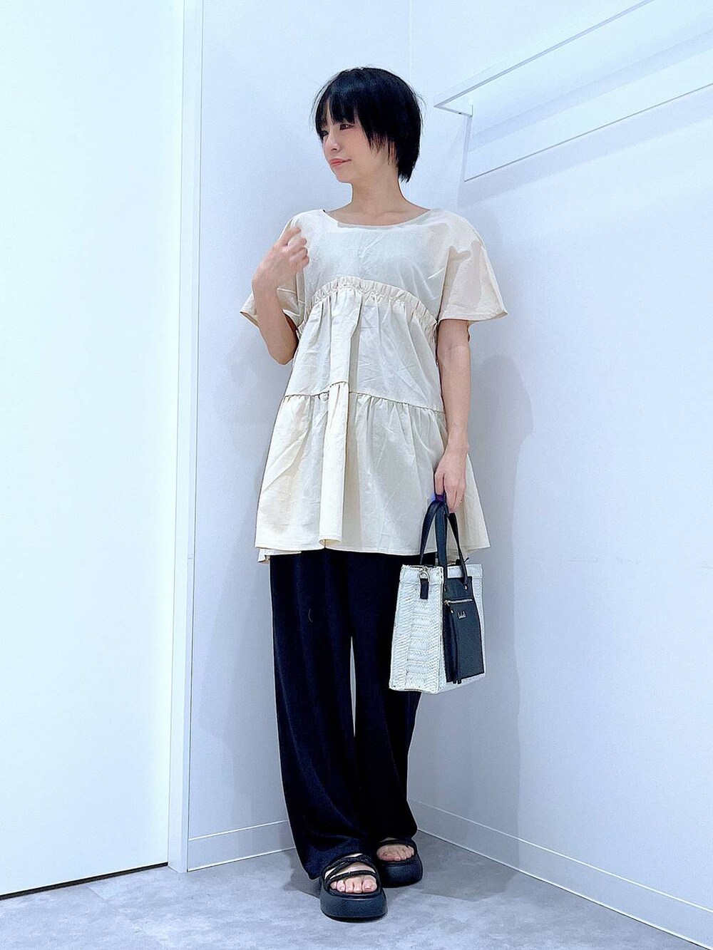 ホワイト系のショルダーバッグ、ブラック系のサンダル、ブラック系のその他パンツを着用したレディースの夏コーディネートの2枚目の写真