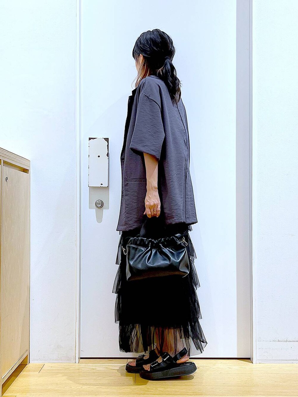 ブラック系のサンダル、ブラック系のショルダーバッグ、ブラック系のスカートを着用したレディースの夏コーディネートの3枚目の写真