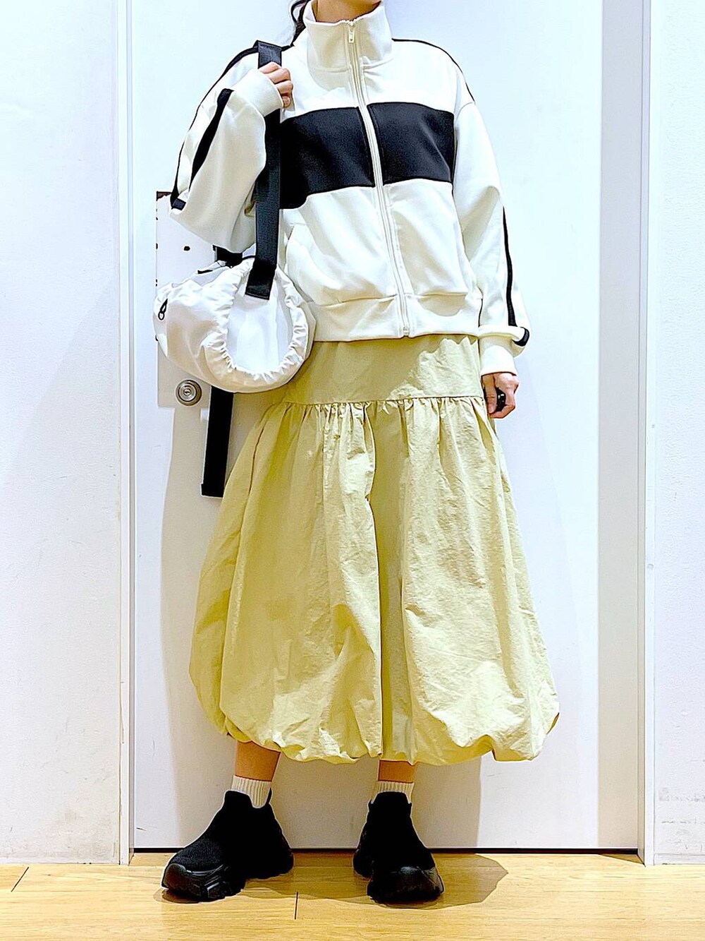 ベージュ系のブルゾン、ベージュ系のスカート、ホワイト系のショルダーバッグを着用したレディースの冬コーディネートの6枚目の写真