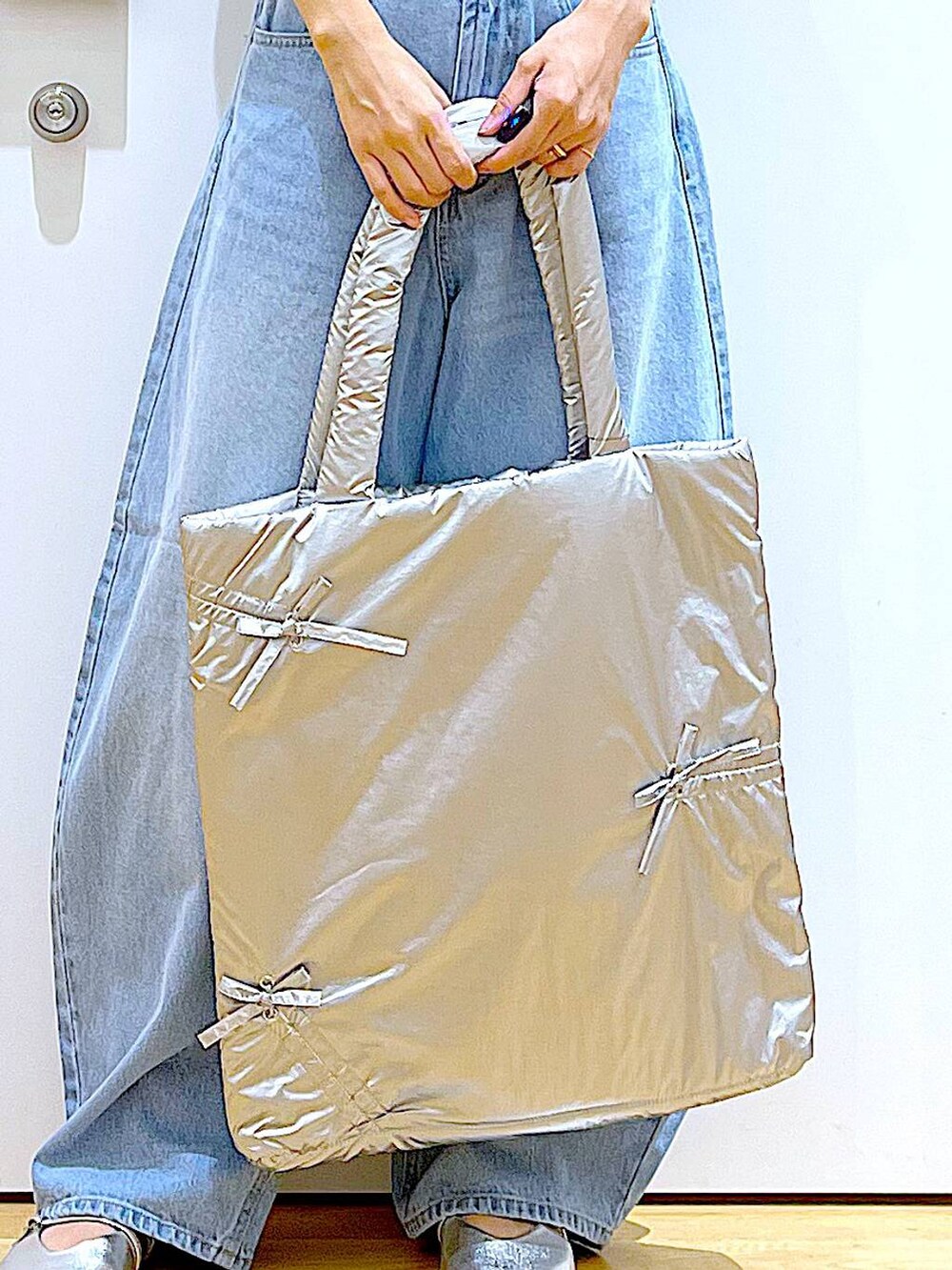 ブラック系のカーディガン/ボレロ、シルバー系のトートバッグ、ブルー系のデニムパンツを着用したレディースの秋コーディネートの9枚目の写真