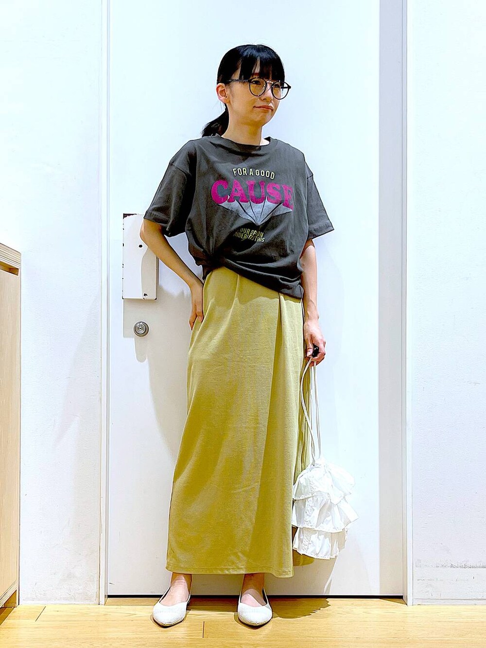 ホワイト系のショルダーバッグ、イエロー系のワンピース、ホワイト系のパンプスを着用したレディースの春コーディネートの2枚目の写真