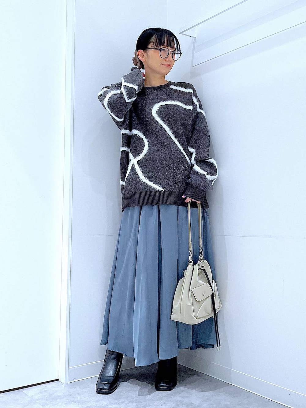 ブラック系のブーツ、グレー系のニット/セーター、ブラウン系のバレッタ/ヘアクリップを着用したレディースの冬コーディネートの2枚目の写真