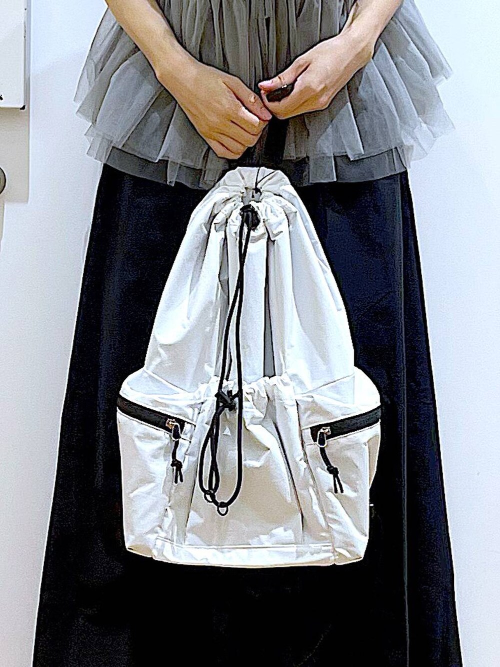 ホワイト系のショルダーバッグ、ホワイト系のサンダル、ブラック系のスカートを着用したレディースの夏コーディネートの9枚目の写真