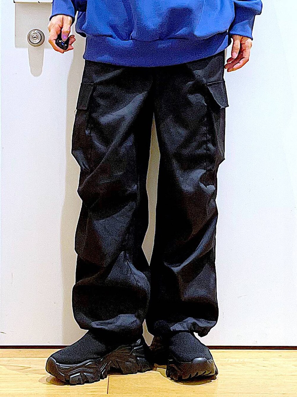 ブラック系のカーゴパンツ、ブラック系のスニーカー、ブルー系のスウェットを着用したレディースの冬コーディネートの8枚目の写真