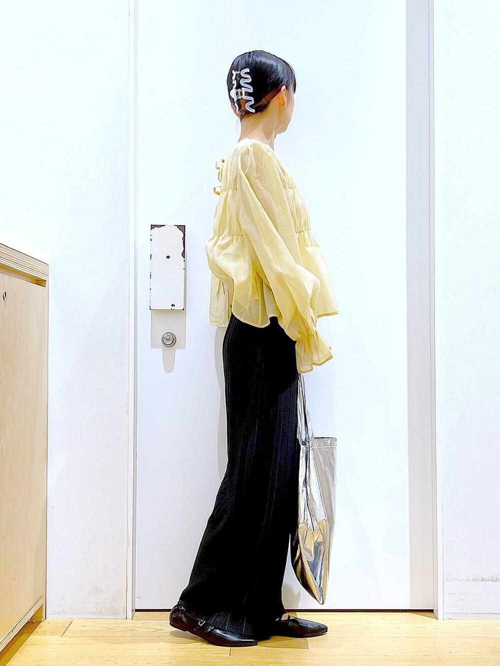 シルバー系のトートバッグ、ブラック系のその他パンツ、ブラック系のパンプスを着用したレディースの秋コーディネートの4枚目の写真