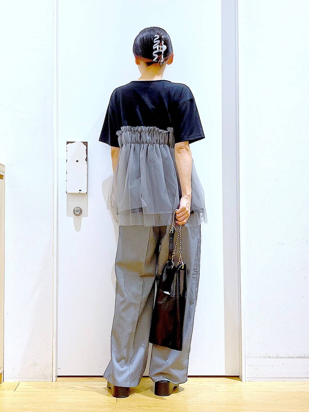ブラック系のショルダーバッグ、ブラック系のサンダル、ブラック系のTシャツ/カットソーを着用したレディースの夏コーディネートの5枚目の写真