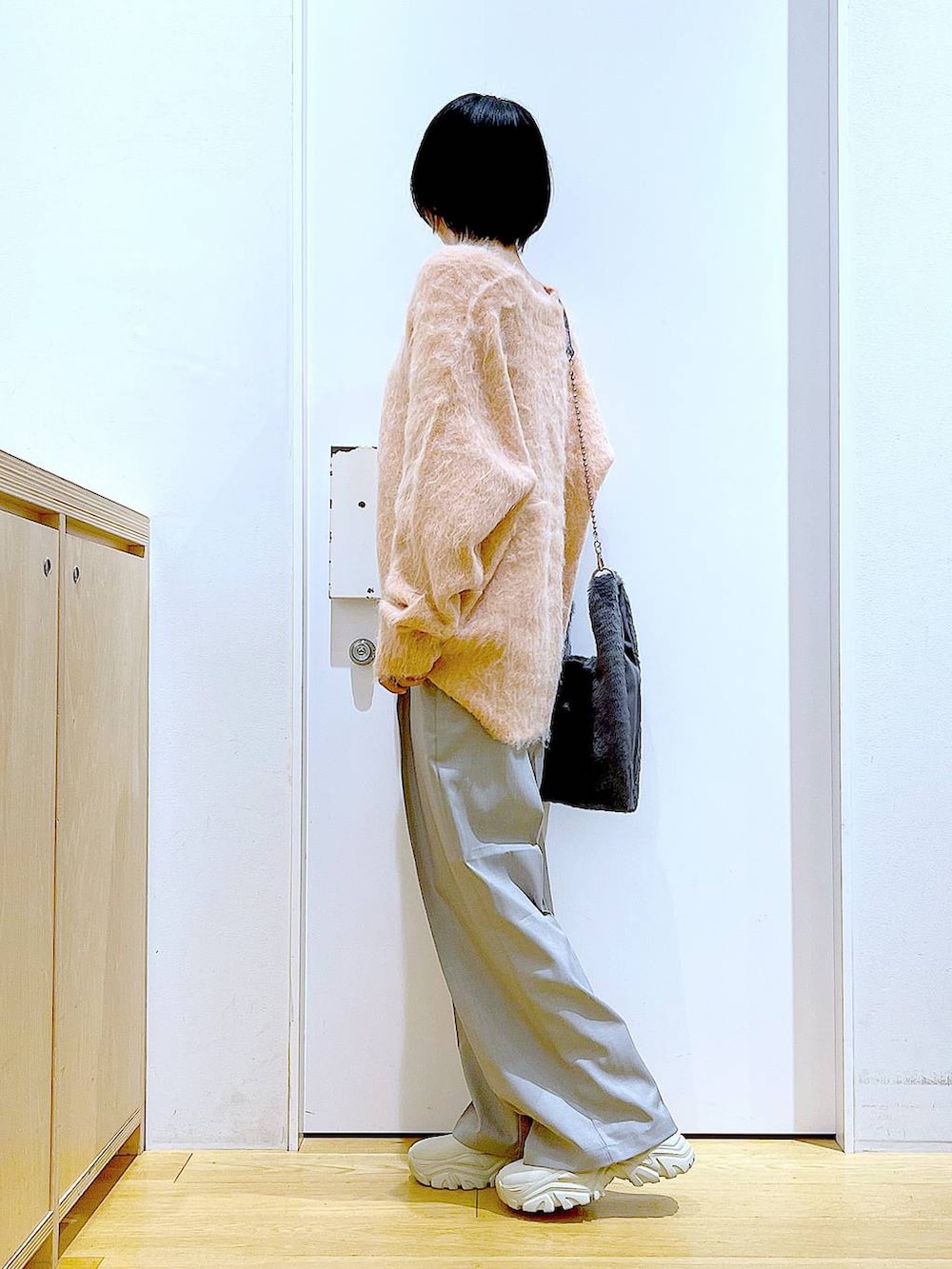 ピンク系のカーディガン/ボレロ、グレー系のショルダーバッグ、ベージュ系のブーツを着用したレディースの冬コーディネートの4枚目の写真
