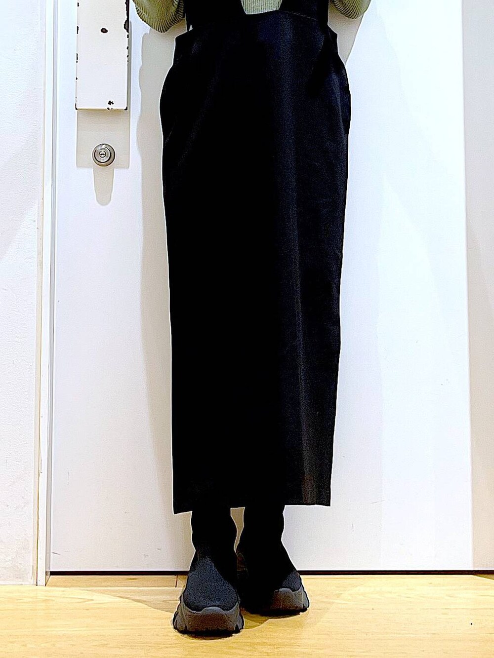 グリーン系のニット/セーター、ブラック系のブーツ、ブラック系のサロペット/オーバーオールを着用したレディースの冬コーディネートの8枚目の写真