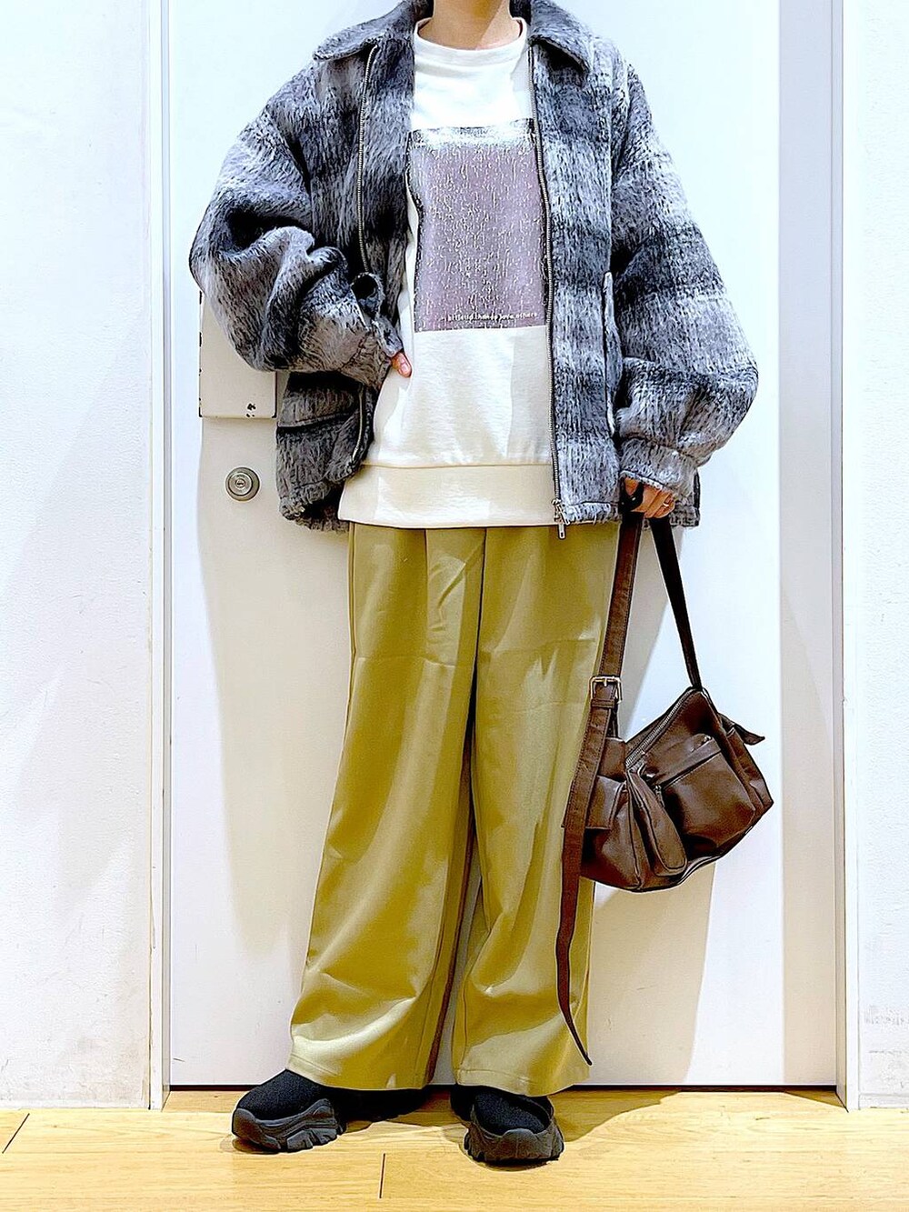 その他のブルゾン、ブラック系のブーツ、イエロー系のその他パンツを着用したレディースの冬コーディネートの6枚目の写真