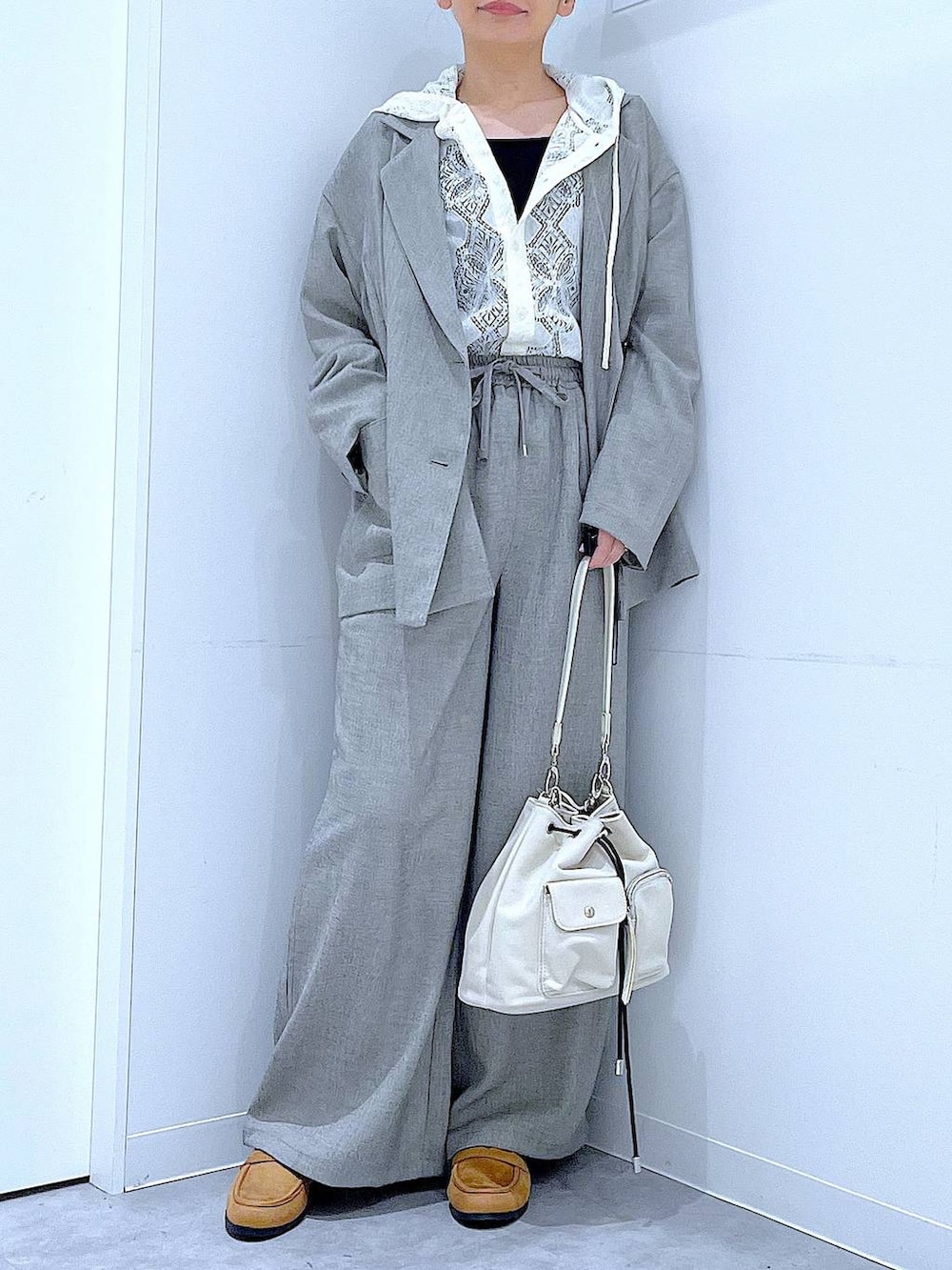 ホワイト系のショルダーバッグ、ベージュ系のローファー、ホワイト系のシャツ/ブラウスを着用したレディースの春コーディネートの6枚目の写真