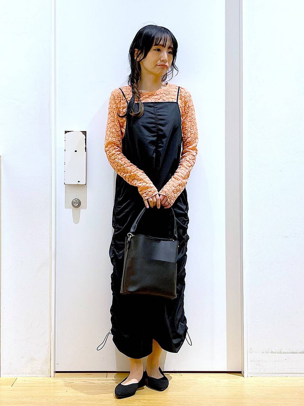 ブラック系のワンピース、ブラック系のショルダーバッグ、ブラック系のパンプスを着用したレディースの春コーディネートの2枚目の写真