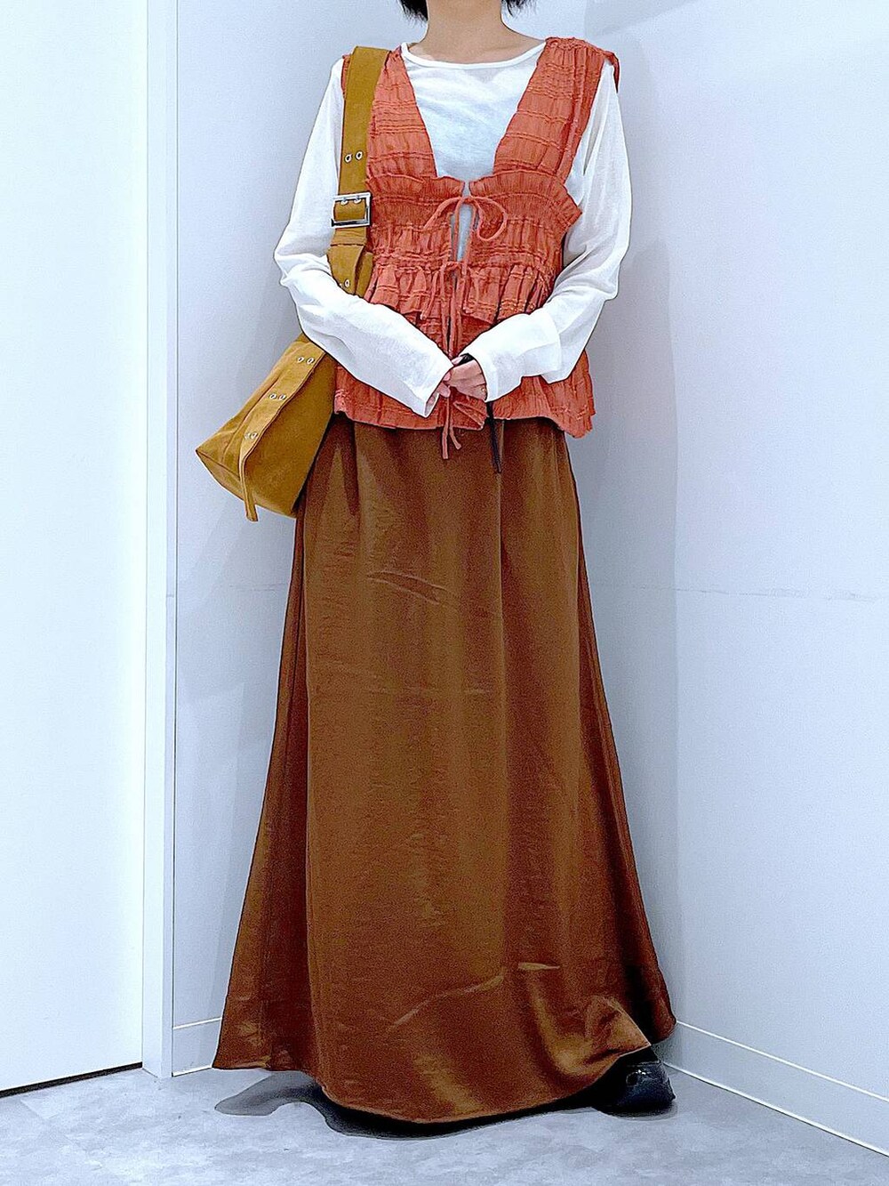 ホワイト系のTシャツ/カットソー、ブラック系のローファー、ブラウン系のスカートを着用したレディースの秋コーディネートの6枚目の写真